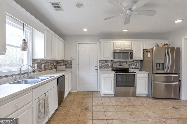 kitchen with stainless steel appliances, a sink, visible vents, white cabinetry, and light countertops