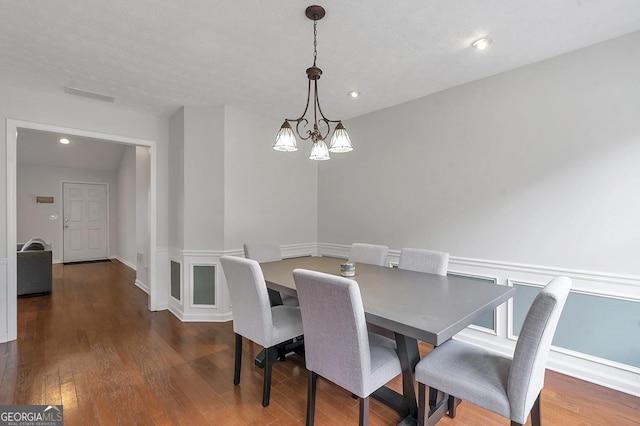 dining room with baseboards, visible vents, hardwood / wood-style floors, a chandelier, and recessed lighting