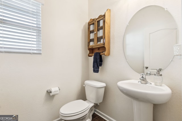 half bathroom featuring toilet and baseboards