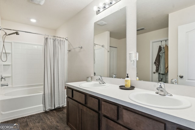 bathroom featuring wood finished floors, a sink, visible vents, and shower / bathtub combination with curtain