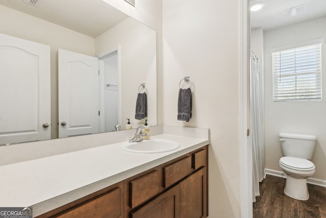 full bathroom featuring toilet, wood finished floors, vanity, and baseboards