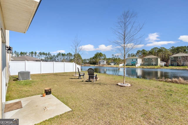 view of yard with a water view, fence, and cooling unit