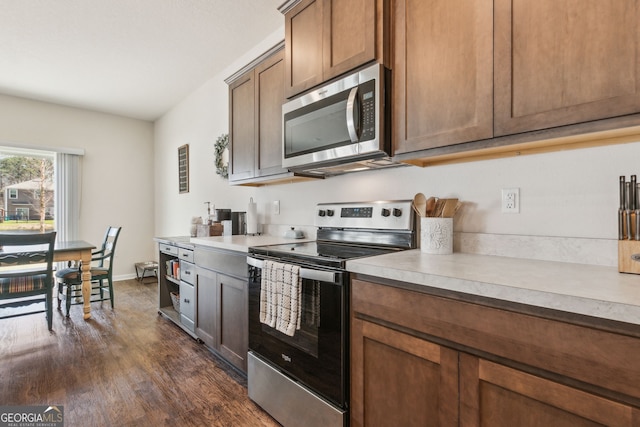 kitchen featuring dark wood-style floors, baseboards, appliances with stainless steel finishes, and light countertops