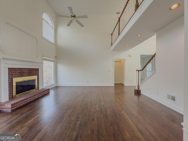 unfurnished living room with a brick fireplace, a healthy amount of sunlight, visible vents, and baseboards