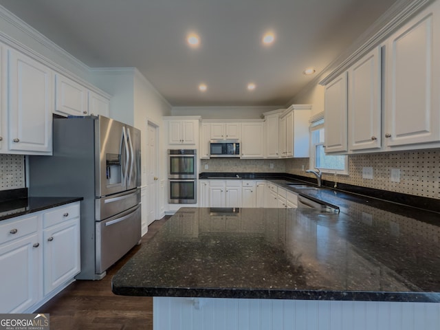 kitchen featuring crown molding, backsplash, appliances with stainless steel finishes, white cabinetry, and a sink