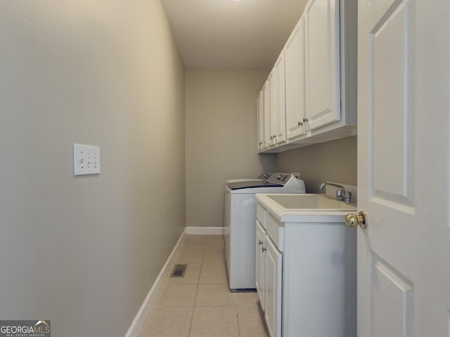 washroom featuring light tile patterned floors, washing machine and dryer, visible vents, baseboards, and cabinet space