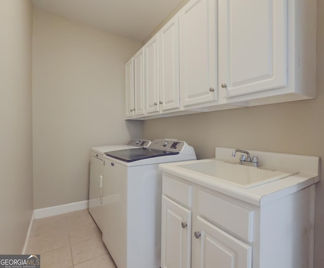 clothes washing area featuring light tile patterned flooring, independent washer and dryer, cabinet space, and baseboards