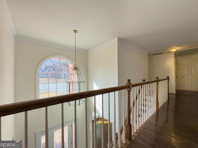 corridor with wood finished floors, an upstairs landing, visible vents, and crown molding