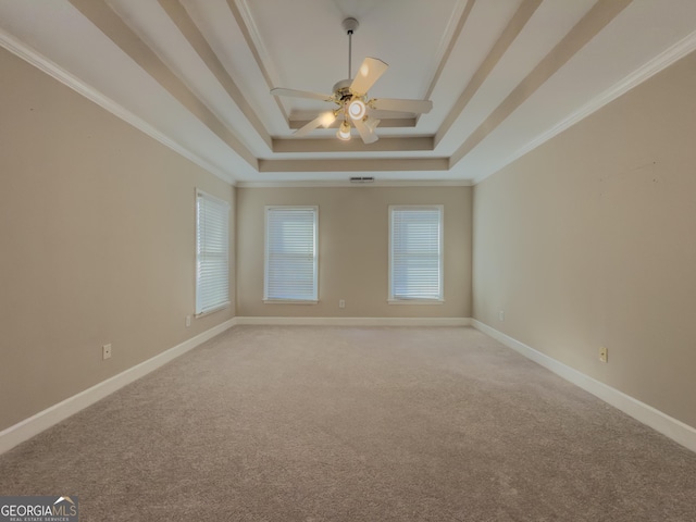 unfurnished room with ceiling fan, a raised ceiling, light colored carpet, and baseboards