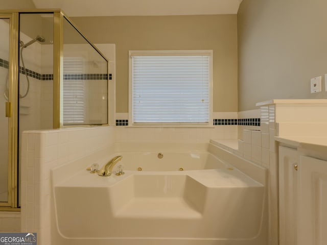 full bathroom with a jetted tub, a stall shower, and vanity