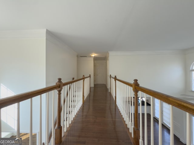 corridor with an upstairs landing, visible vents, dark wood-type flooring, and ornamental molding