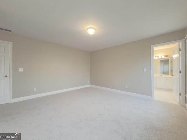 unfurnished room featuring visible vents, baseboards, and light colored carpet