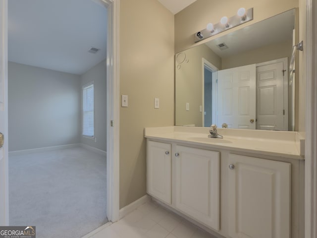 bathroom with visible vents, vanity, baseboards, and tile patterned floors