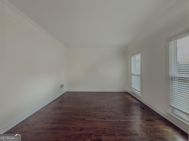 spare room featuring dark wood-style floors, baseboards, a wealth of natural light, and crown molding