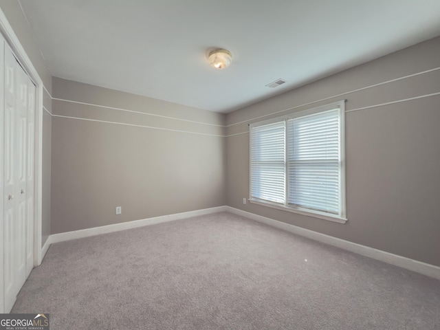 unfurnished bedroom with carpet floors, visible vents, and baseboards