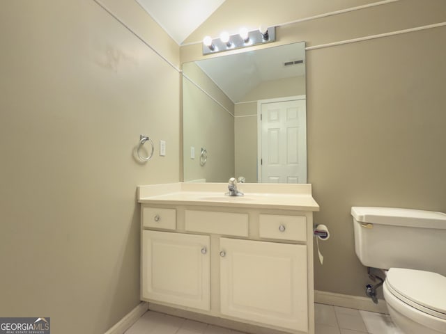 bathroom with baseboards, lofted ceiling, toilet, tile patterned floors, and vanity