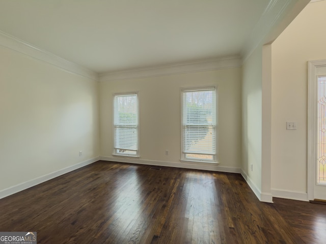 empty room featuring dark wood-style floors, baseboards, and crown molding