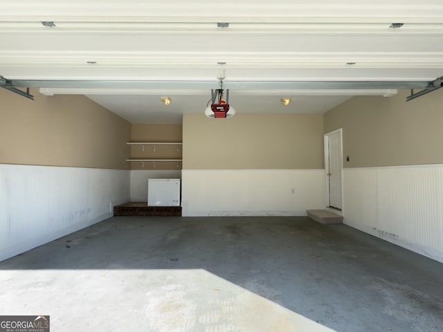 garage featuring a garage door opener and wainscoting