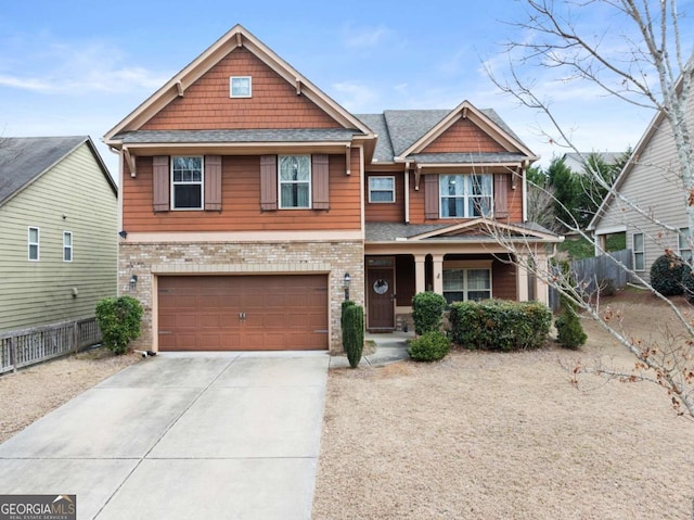 craftsman inspired home featuring a garage, fence, concrete driveway, and brick siding