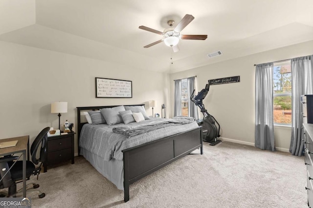 bedroom with baseboards, a tray ceiling, and light colored carpet