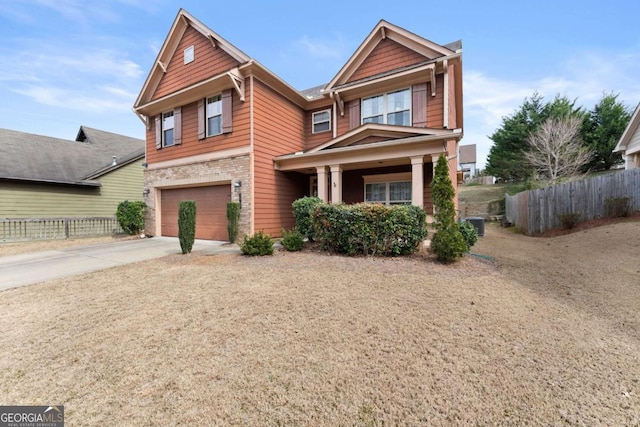 craftsman-style home featuring concrete driveway, fence, and an attached garage