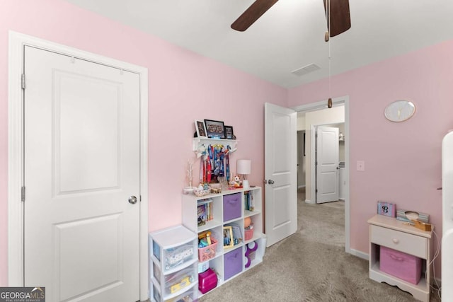 recreation room with carpet floors, a ceiling fan, and baseboards