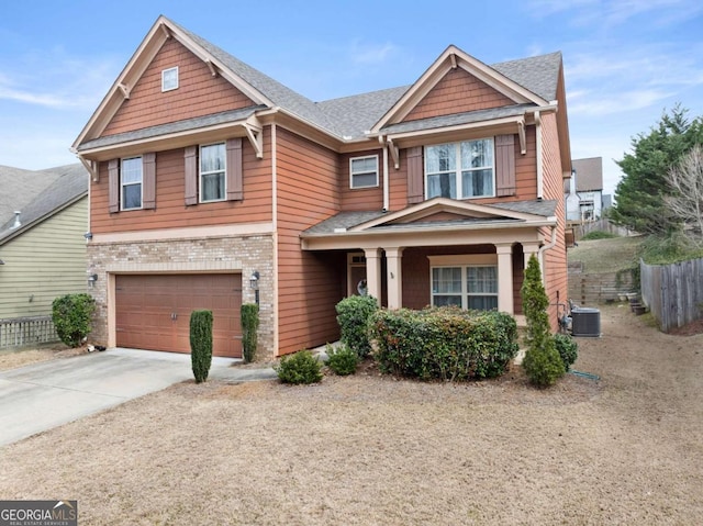 craftsman inspired home with brick siding, central AC unit, fence, a garage, and driveway