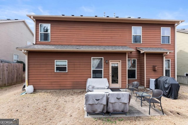 rear view of house with a patio and fence