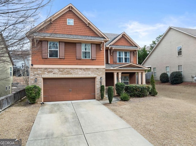 craftsman inspired home with concrete driveway, brick siding, fence, and an attached garage