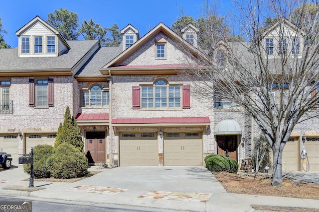 view of property featuring brick siding, driveway, an attached garage, and roof with shingles