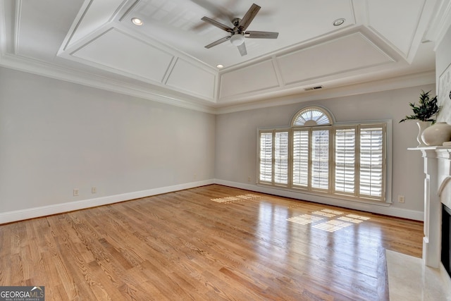 unfurnished living room featuring visible vents, light wood-style flooring, a premium fireplace, coffered ceiling, and baseboards