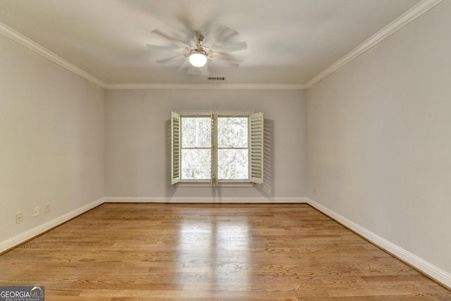 empty room with a ceiling fan, visible vents, crown molding, and wood finished floors