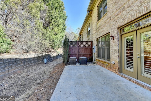 view of patio with central air condition unit and fence