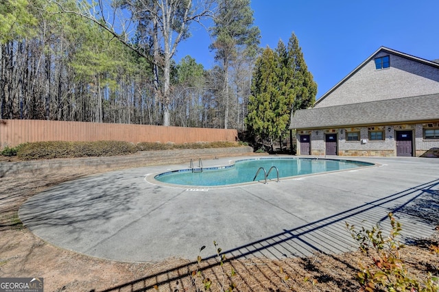 community pool featuring a patio area and fence