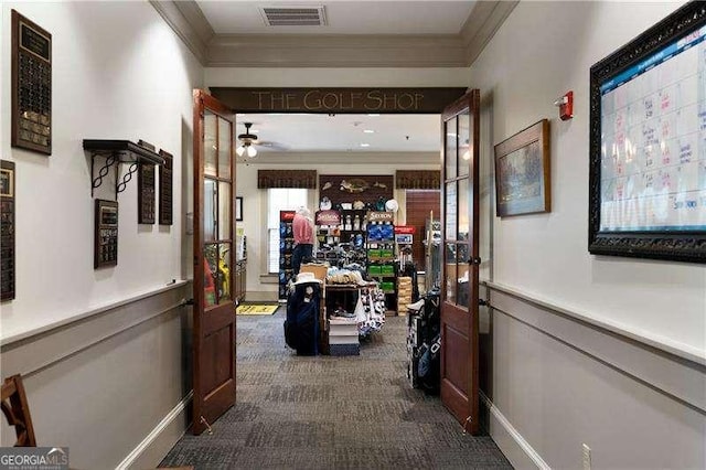 hallway featuring ornamental molding, dark carpet, and visible vents