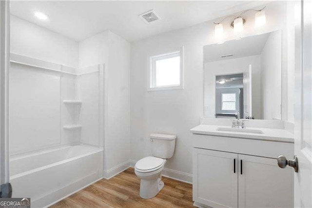 bathroom with baseboards, visible vents, toilet, wood finished floors, and vanity