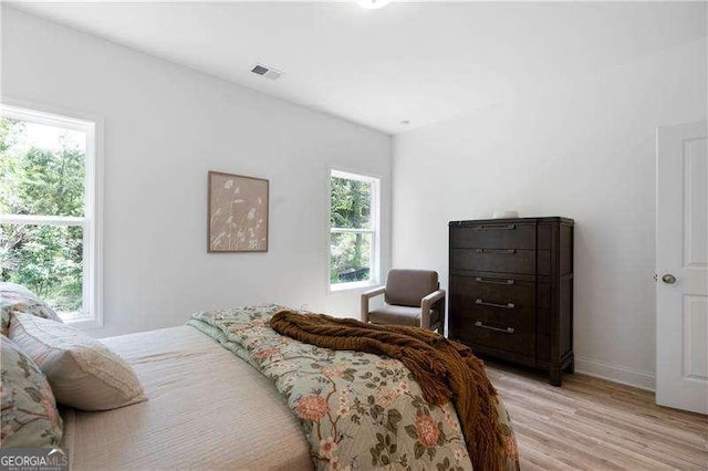 bedroom featuring light wood-type flooring, baseboards, and visible vents