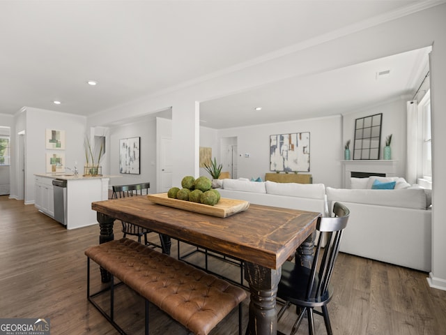 dining space with ornamental molding, wood finished floors, and recessed lighting