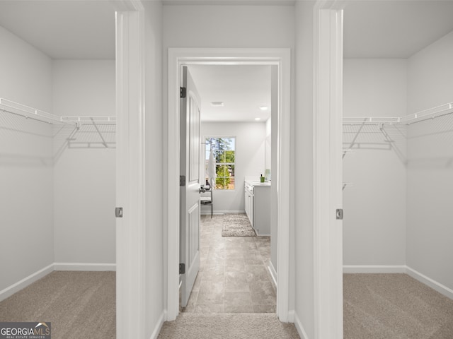 walk in closet featuring light carpet