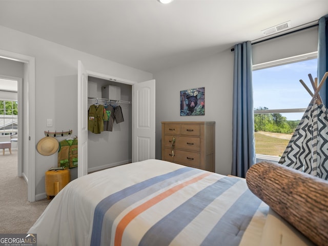 carpeted bedroom featuring baseboards, visible vents, and a closet