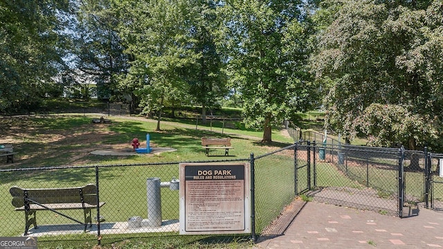 view of community with a gate, a yard, and fence