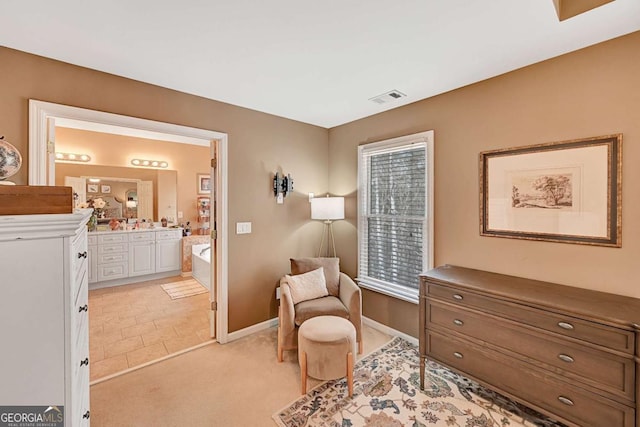 sitting room featuring light colored carpet, visible vents, and baseboards