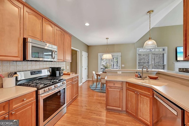 kitchen with appliances with stainless steel finishes, light countertops, and a sink