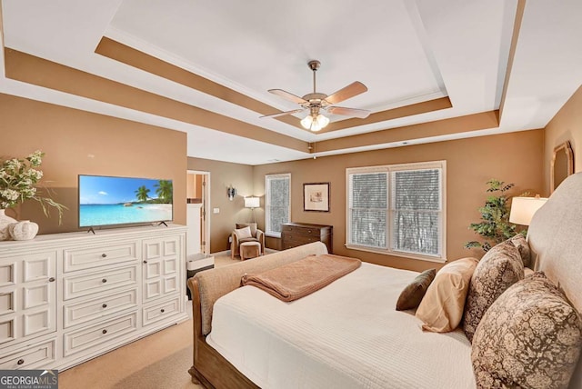 bedroom with ceiling fan, multiple windows, a raised ceiling, and light colored carpet