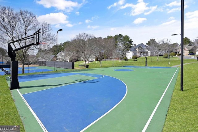 view of sport court with community basketball court, fence, and a lawn