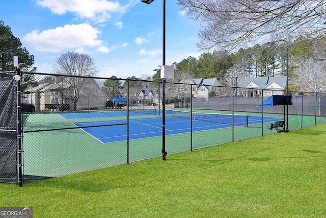 view of sport court with a yard, a residential view, and fence