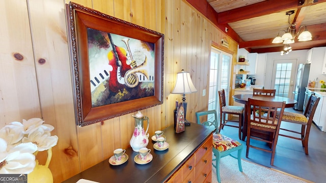 dining space featuring wood ceiling, wood walls, beam ceiling, and a notable chandelier