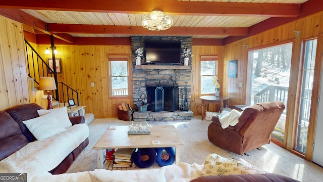 carpeted living room with a healthy amount of sunlight, wood walls, stairs, and a fireplace