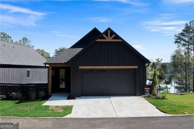 modern farmhouse featuring an attached garage, driveway, and a front lawn