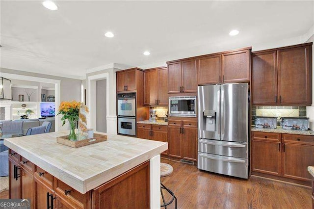 kitchen with dark wood-style floors, stainless steel appliances, and light countertops